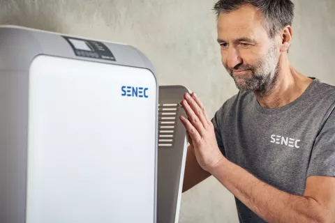 Ein Installateur schließt die seitliche Klappe an einem Stromspeicher.